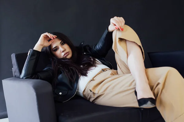Портрет красивой модной восточной брюнетки на черном диване — стоковое фото