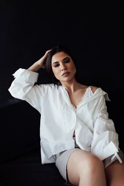 Retrato de una hermosa mujer morena de moda en una camisa blanca para hombre — Foto de Stock