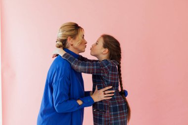 Anne-kız aile fotoğrafı, pembe bir arka plan.