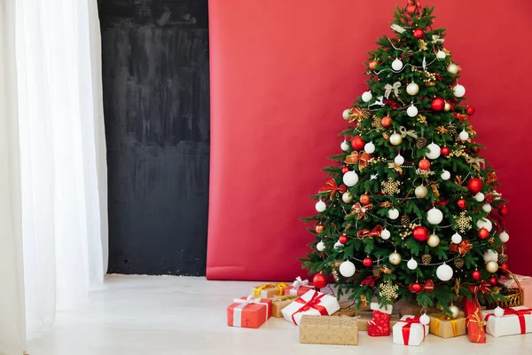 Árbol de Navidad con regalos de luces de guirnalda para el nuevo año en el interior de la habitación como fondo rojo —  Fotos de Stock