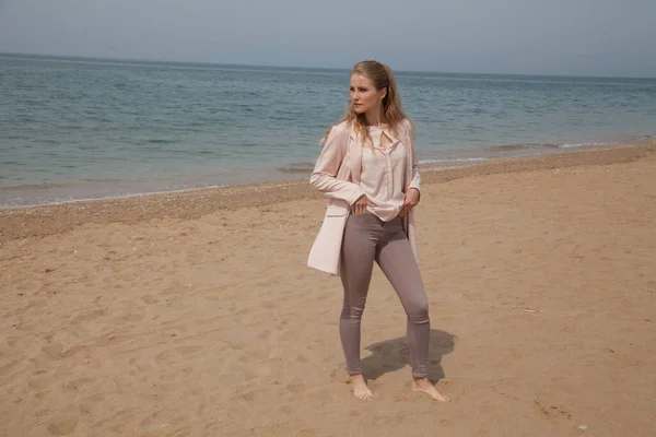 Красива блондинка гуляє на порожньому пляжі біля самого моря — стокове фото