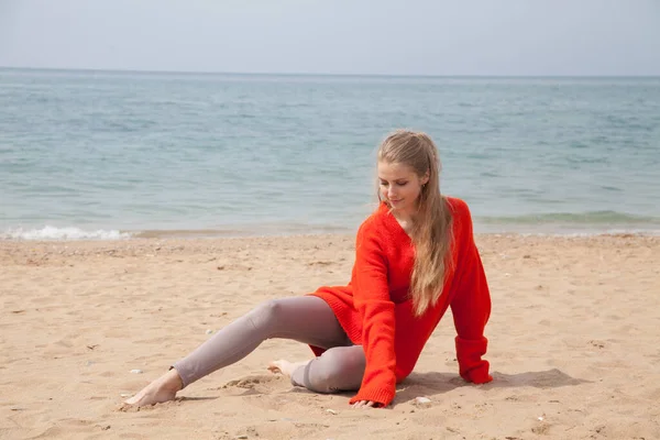 Красива блондинка сидить на пляжі один біля моря — стокове фото