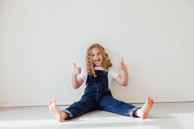 Kot pantolon giymiş güzel sarışın bir kızın portresi.