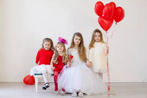 Дитячі друзі сидять з червоними кульками в день народження — стокове фото