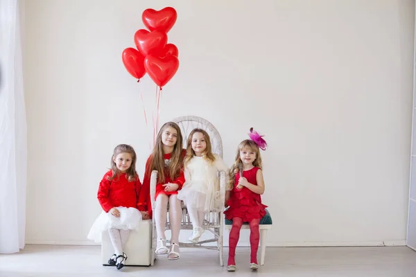 Amici per bambini si siedono con palloncini rossi per il compleanno delle vacanze — Foto Stock