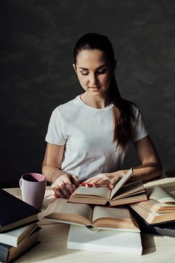 Kız sınava hazırlanıyor ve bir kitap okuyor.
