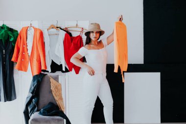 Elbise seçen kadın büyük gardırop dolabından şık kıyafetler ve ev eşyaları ile