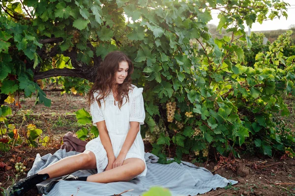 Gyönyörű nő fehér ruhában egy pikniken a szőlőfa mellett — Stock Fotó