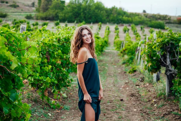 Красива жінка в одязі з келихом вина на пікніку в винограднику — стокове фото