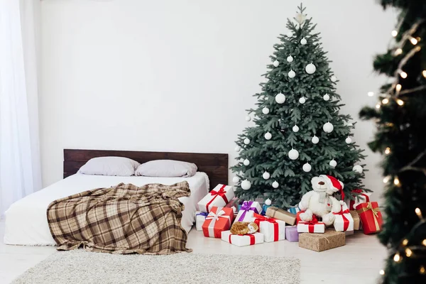 Nieuwjaar kaart slaapkamer interieur met rood bed decor en kerstboom met geschenken — Stockfoto