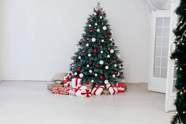 Beyaz odanın yeni yıl kartı, kırmızı dekor ve hediyeli Noel ağacı. — Stok fotoğraf