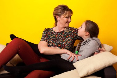 Anne ve kızı aşk odasındaki kanepede oturuyor.