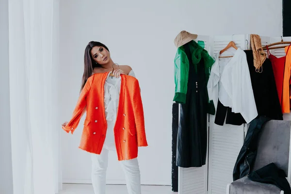 shopping woman trying clothes. Woman choosing between summer dresses looking in mirror.