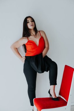 Kırmızı iş elbiseli güzel esmer kadın iş yerinde, beyaz ofiste.