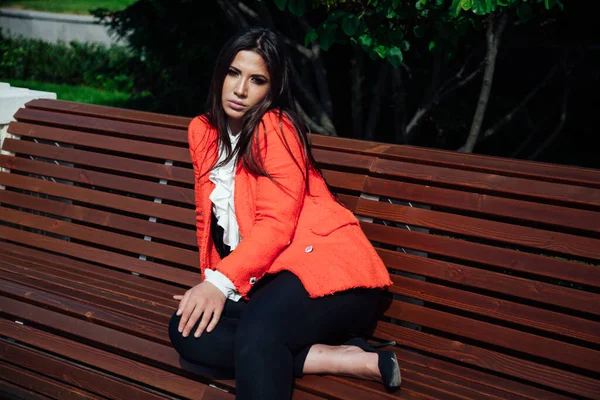 Schöne Mode-Geschäft brünette Frau sitzt auf einer Bank auf der Straße ausruhen — Stockfoto