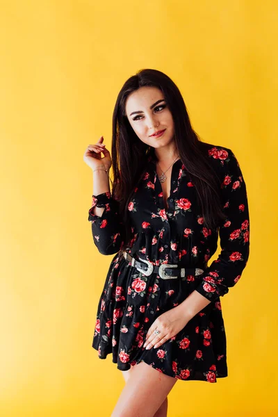 Hermosa mujer morena en vestido negro con flores posando — Foto de Stock