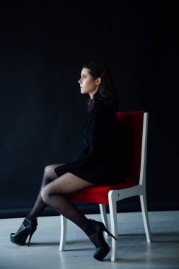 Siyah erkek ceketi giymiş, şık, esmer bir kadının portresi.