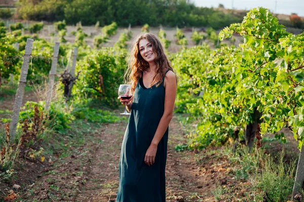 Bella donna in abito beve vino nei vigneti — Foto Stock