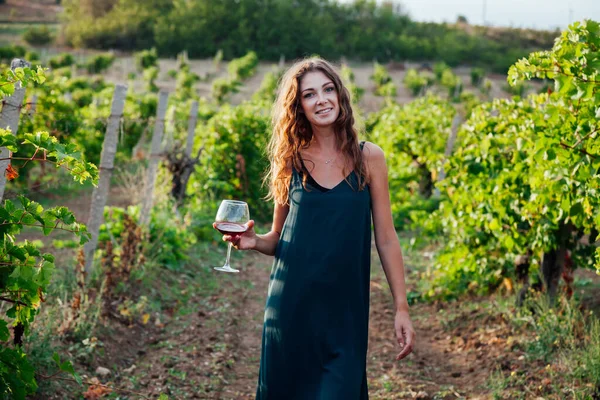 Bella donna in abito beve vino nei vigneti — Foto Stock