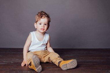 Pantolon ve beyaz tişörtlü güzel bir çocuğun portresi.