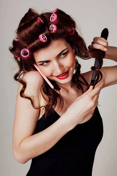 Beautiful woman prepares hair curls twists hair