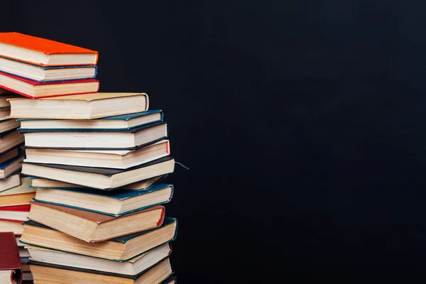 Stapel von Büchern für den Unterricht in der Bibliothek auf schwarzem Hintergrund zur Beschriftung — Stockfoto