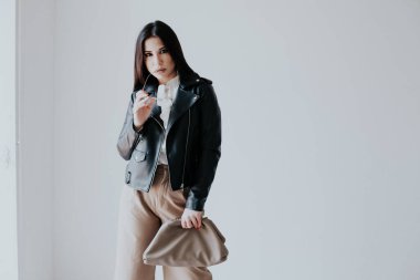 Siyah deri ceketli, şık esmer bir kadın.