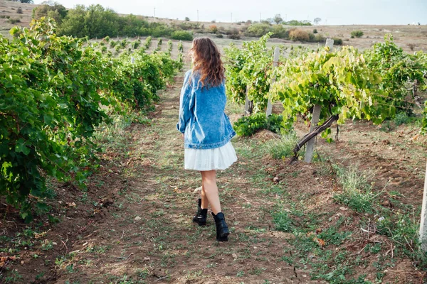Krásná žena v bílých šatech a džínové bundy ve vinicích — Stock fotografie