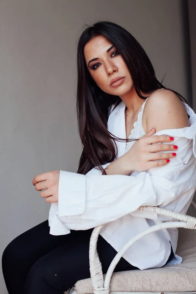 Beautiful fashionable brunette woman in white shirt and black pants — Stock Photo, Image