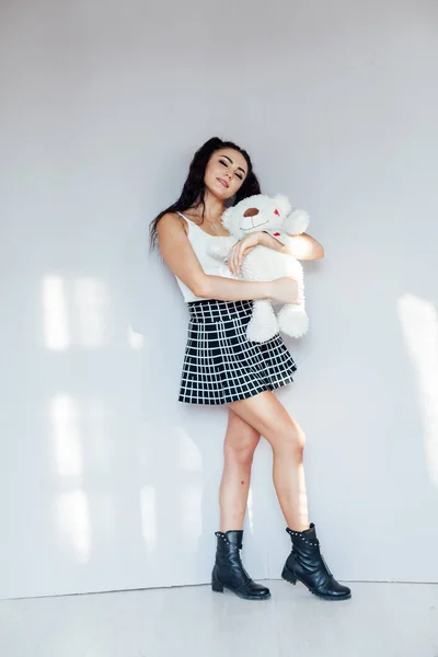 Portrait of a beautiful fashionable brunette woman with a soft toy bear — Stock Photo, Image