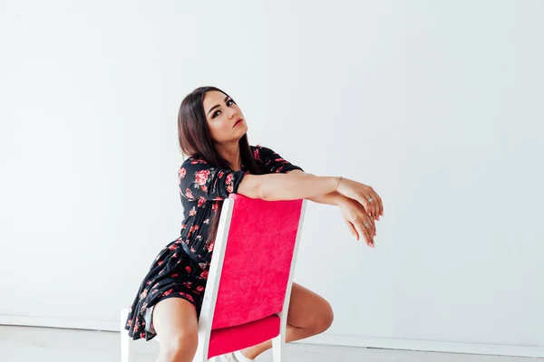 Portrait of a beautiful fashionable woman in a black dress with flowers — Stock Photo, Image