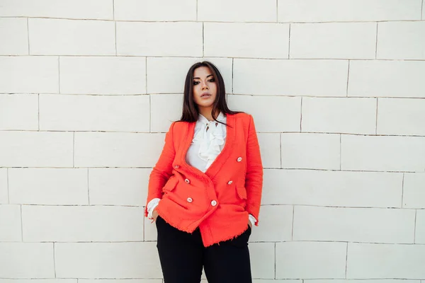 Красива бізнес брюнетка жінка в помаранчевому діловому костюмі на вулиці — стокове фото