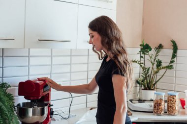 Kadın mutfakta mutfak hasatçısıyla yemek hazırlıyor.