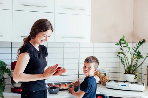 Frau und Sohn kochen süße Kuchen in der Küche — Stockfoto