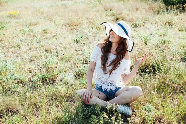 Retrato de uma bela mulher na moda em um chapéu em um campo sozinho — Fotografia de Stock