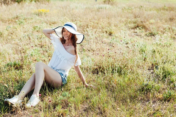 Retrato de uma bela mulher na moda em um chapéu em um campo sozinho — Fotografia de Stock