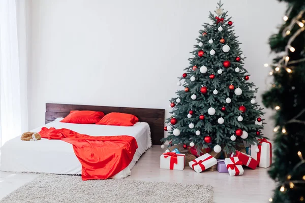 Ein geräumiges weißes Schlafzimmer im Loft-Stil mit geschmücktem Weihnachtsbaum — Stockfoto