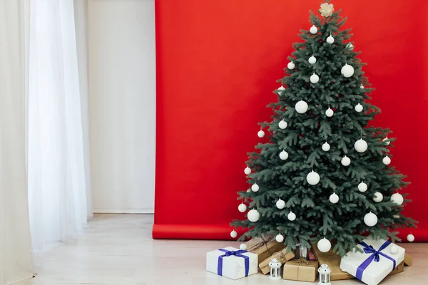 Decoración del árbol de Navidad rojo de Año Nuevo con regalos y guirnaldas interiores —  Fotos de Stock