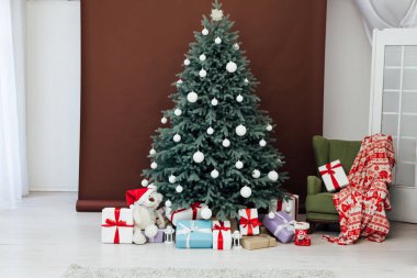 Yeni Yıl Kırmızı Noel Ağacı dekoru, içinde hediyeler ve çelenkler.