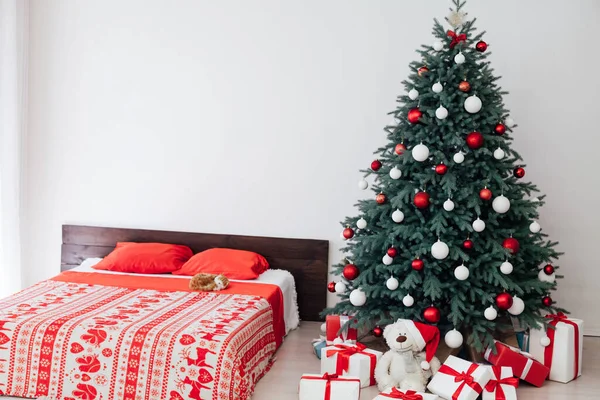 Ano Novo decoração do quarto com cama de árvore de Natal com presentes e guirlandas interior — Fotografia de Stock