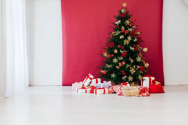 Árbol de Navidad con bolas de colores y cajas de regalo sobre la pared blanca —  Fotos de Stock