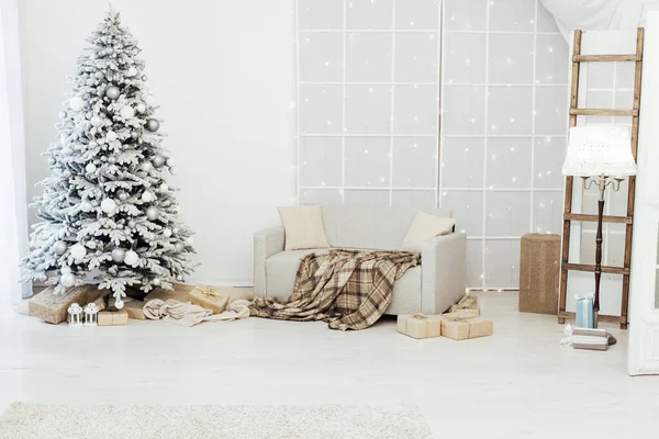 Binnenland. Een kamer met een prachtige besneeuwde kerstboom en geschenken onder deze boom. — Stockfoto