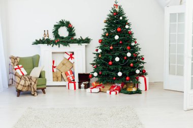 Beyaz oda Noel ağacı çam şöminesi ve yeni yıl dekorasyon hediyeleri.