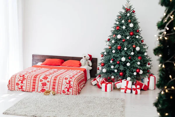 Dormitorio con cama de pino árbol de Navidad con regalos año nuevo decoración interior —  Fotos de Stock