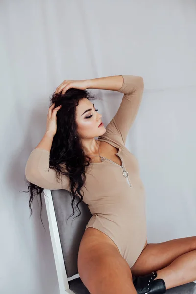 Retrato de una hermosa morena de moda en lencería beige se sienta — Foto de Stock