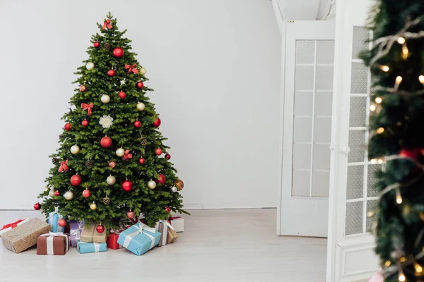Árvore de Natal com decoração do presente bolas guirlandas ano novo interior — Fotografia de Stock