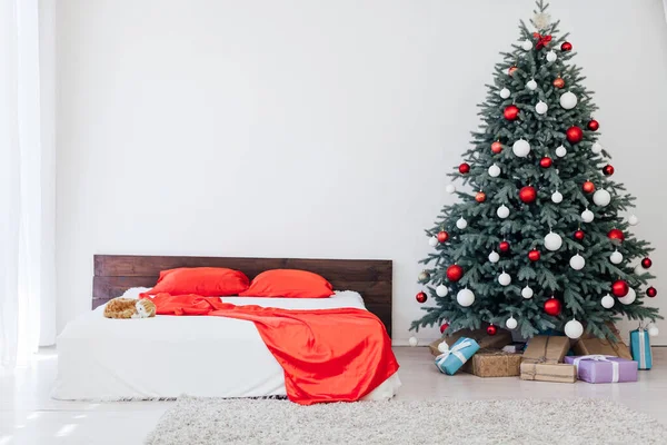 Kerstboom met geschenken in de slaapkamer bed bloemenslingers het nieuwe jaar interieur — Stockfoto