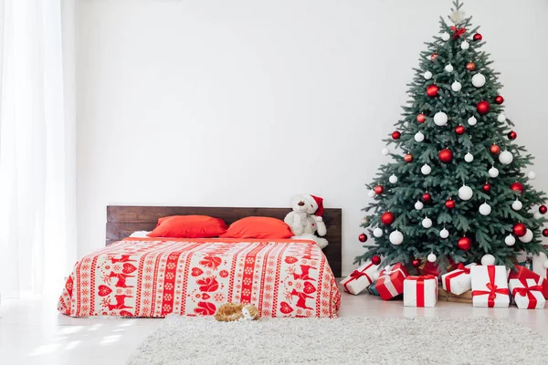 Kerstboom met geschenken in de slaapkamer bed bloemenslingers het nieuwe jaar interieur — Stockfoto