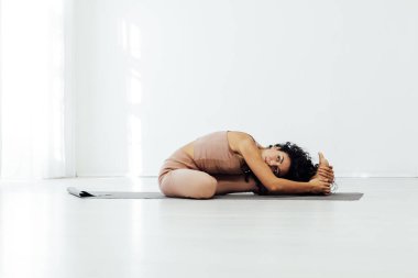 Güzel kadın esmer yoga asana vücut spor salonunun esnekliğini esnetiyor.