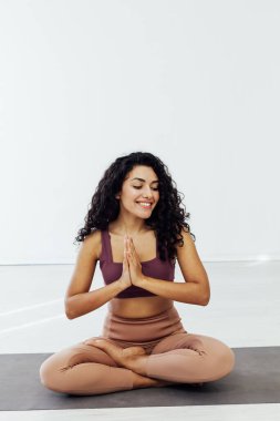 Güzel kadın esmer yoga asana vücut spor salonunun esnekliğini esnetiyor.